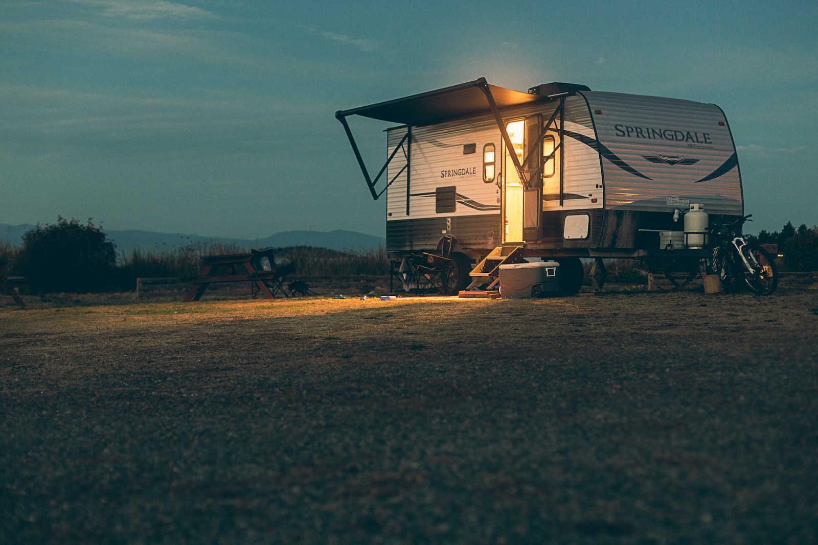 a small camper sits in a field at night